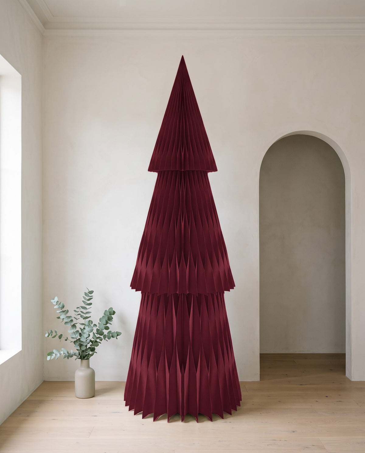 Forma paper Christmas tree, 240cm, in Burgundy, in a white room beside an arched doorway