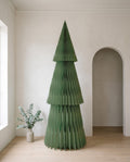 Forma paper Christmas tree, 240cm, in Sage, in a white room beside an arched doorway