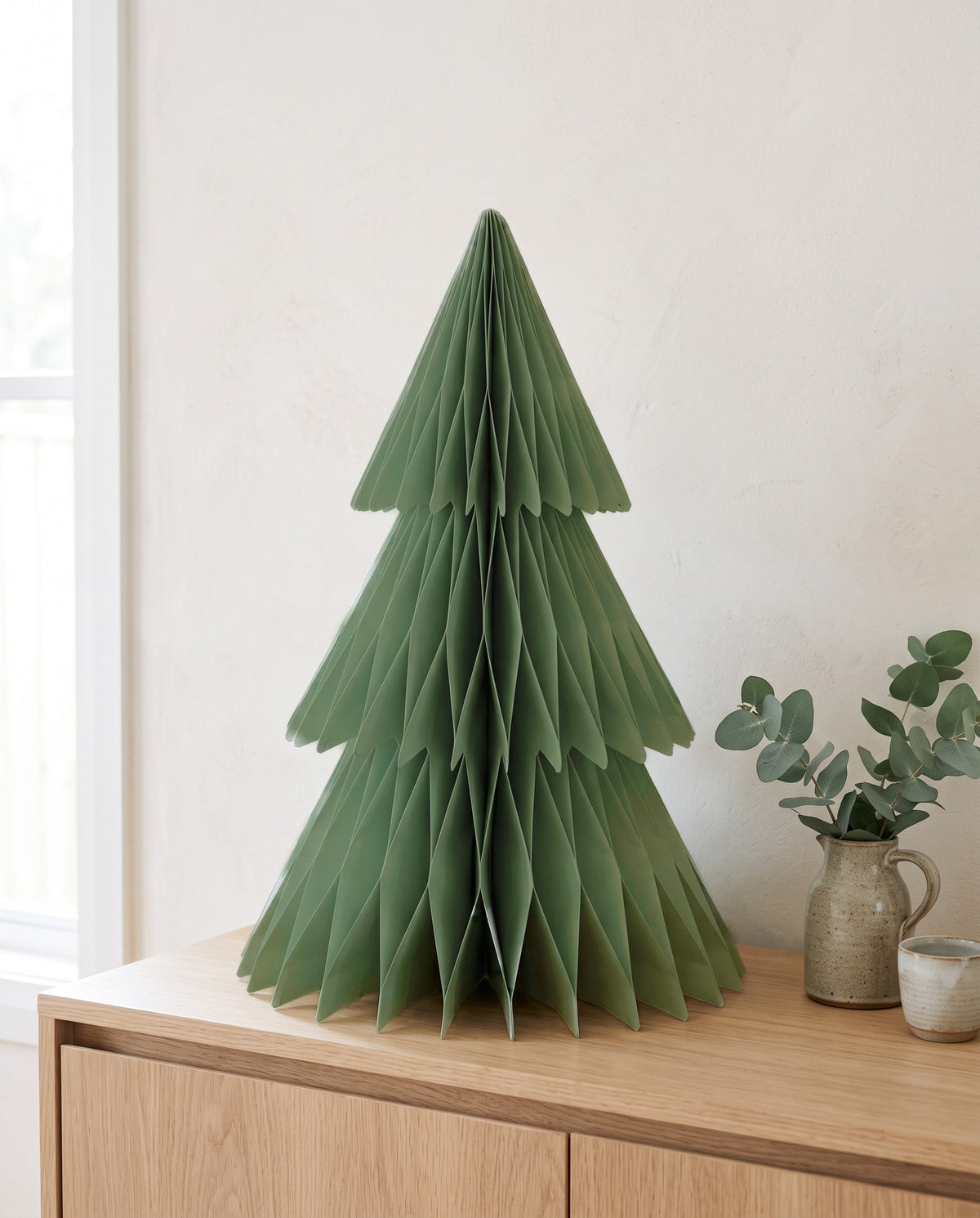 Forma paper Christmas tree, 60cm, in Sage, on an oak sideboard